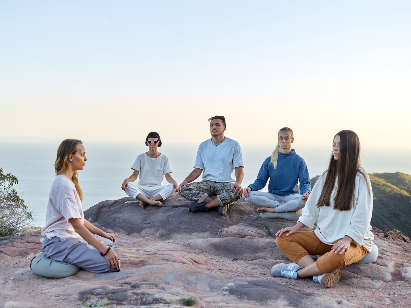 Group of People Sitting Crossed Legged and Meditating 